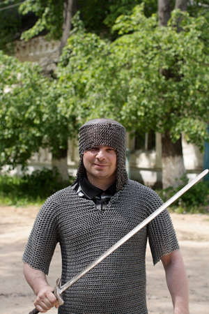 A knight poses in a summer park