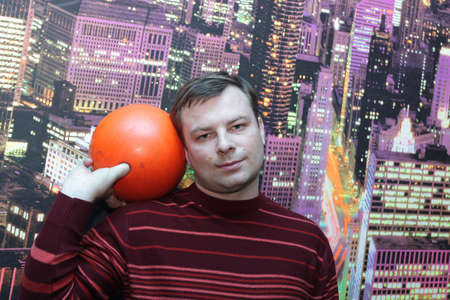 The man poses with  orange bowling ballの写真素材