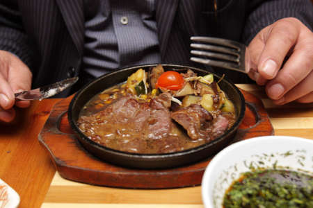A man eats a steak dish in restaurantの写真素材