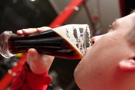 A man drinks a porter in a bar