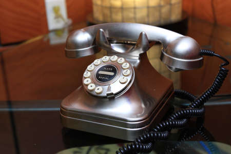The metallic telephone on glass table in hotelの写真素材