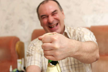 The man opens bottle of champagne at homeの写真素材