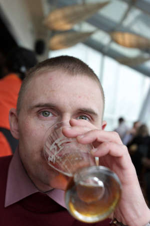 The man drinks a beer in a restaurant