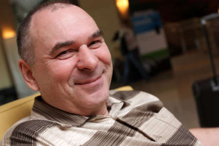 Portrait of happy mature man in hotel