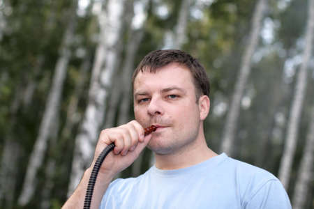 The man smoking a hookah outdoor in summer