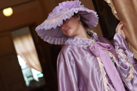 The young woman poses in old-fashioned dressの写真素材