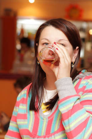 The woman drinks a juice in a restaurant