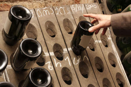 A man takes a bottle of wine in a cellar