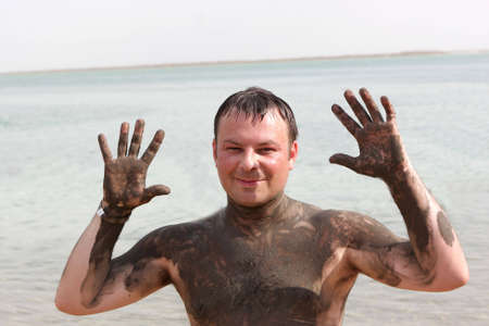 A man with Mineral mud body on a beach of Dead sea