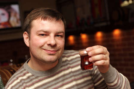 The man poses with cap of black teaの写真素材