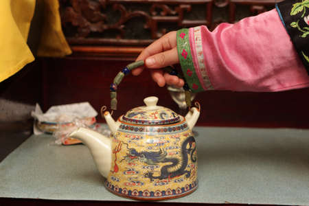 Waitress holding teapot in a china restaurant, Beijingの写真素材