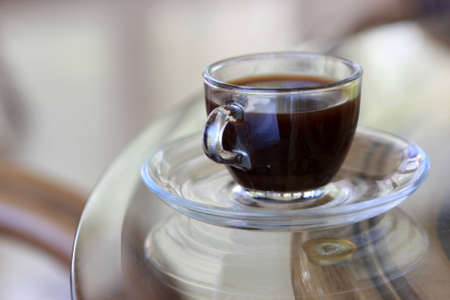 The glass cup of coffee in a cafe