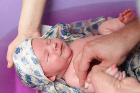 Bathing of baby in a bathtub at home