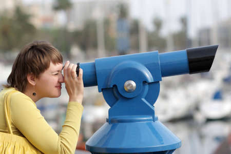 The woman looks through telescope on cityの写真素材