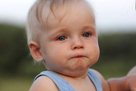 The dissatisfied baby before weeping outdoor at summer