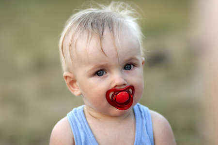 Portrait of dishevelled blond baby outdoor at summerの写真素材