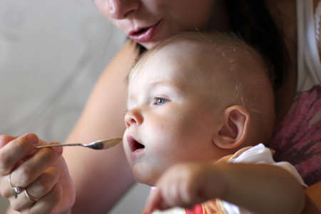 The mother feeds her baby at homeの写真素材