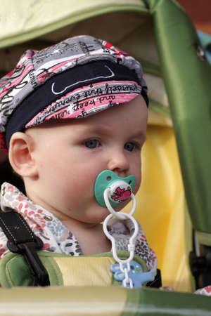 Portrait of serious baby in perambulator outdoor