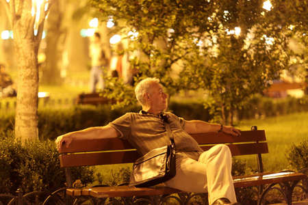 The man sits on a bench in park at night, Odessa, Ukraineの写真素材