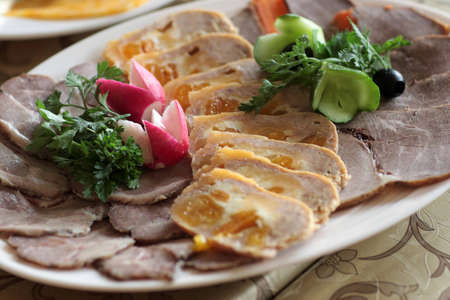 There are pieces of meat, radish and parsley on a plateの写真素材