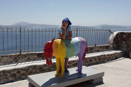 Woman and monument of donkey at Santorini island in Oia. It is town remains one of the foremost tourist attractions of the Aegean Sea. の写真素材