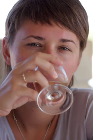 The woman is drinking white wine in the cafe