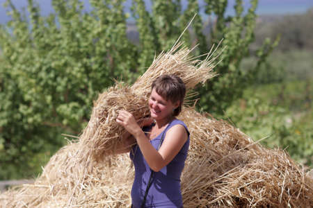 Happy woman poses with armful of wheat, greeceの写真素材