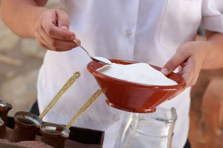 Woman takes sugar for coffee preparation at the restaurantの写真素材