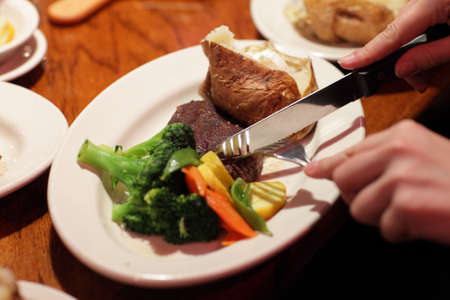 The woman eats filet mignon at the restaurantの写真素材