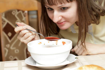 The woman eats soup in the restaurantの写真素材