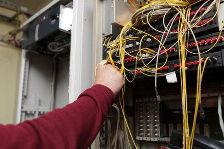 Telecom engineer connecting patch cord from multiplexer to ODFのeditorial素材