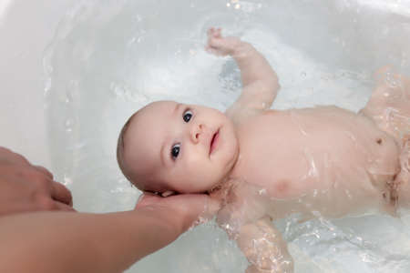 The baby boy having a bath at home