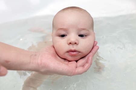 The funny baby taking a bath at home