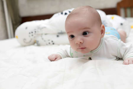 The baby lying on his belly at home