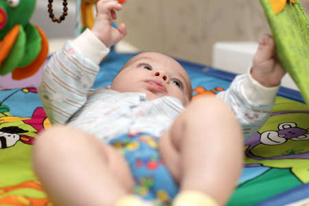 The baby playing on a mat at homeの写真素材