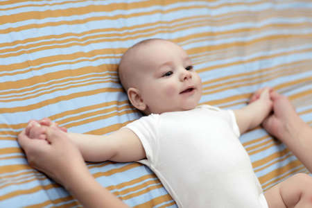 A mother makes gym exersice her baby