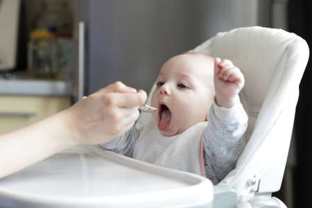 Portrait of eating baby boy at homeの写真素材