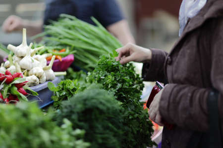 The woman chooses a greens in a marketの写真素材
