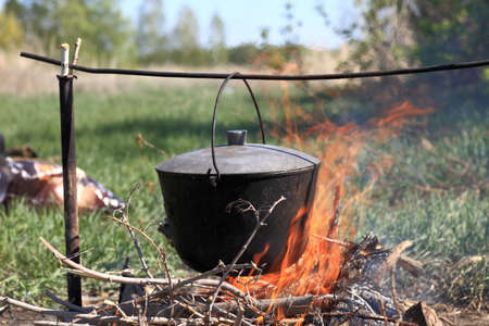 The cauldron hanging above bonfire on picnicの写真素材