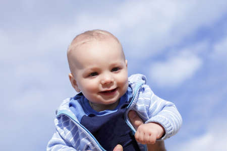 Portait of happy child on the sky backgroundの写真素材