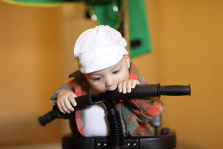 Portrait of funny child with bicycle at homeの写真素材