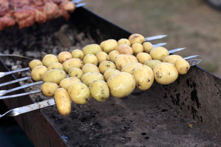 It is cooking potatoes on a skewer grillの写真素材