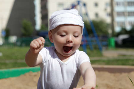 Happy child is playing in sandbox on a playgroundの写真素材