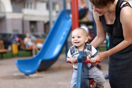Child is swinging on spring toy horse at playgroundの写真素材