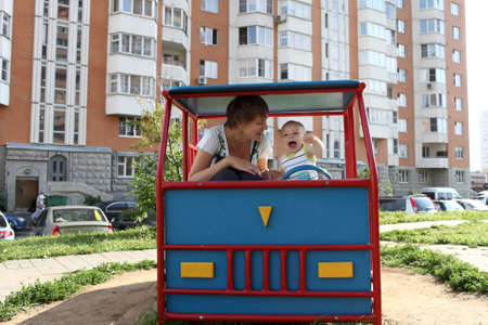 Family is playing in toy car at playgroundの写真素材