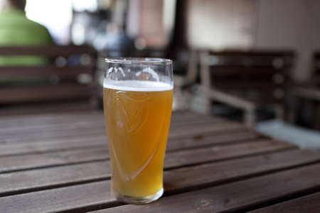 The glass of beer on a wooden table in the pubの写真素材
