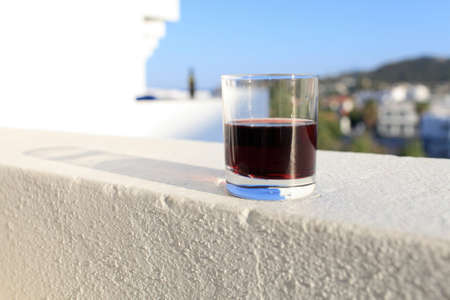 Glass of red wine on a wall of balconyの写真素材