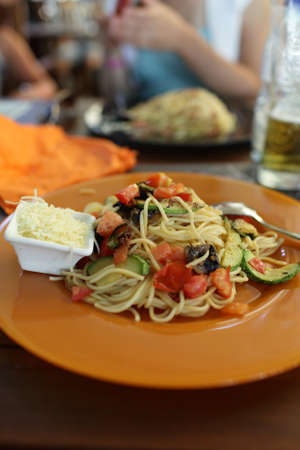 Spaghetti and cheese on a brown plate in an italian restaurantの写真素材