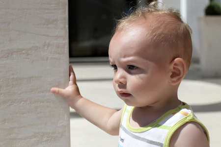 Portrait of a serious baby boy outdoorの写真素材