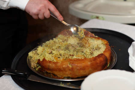 Waiter is putting Khan Pilaf on a plate at a restaurantの写真素材